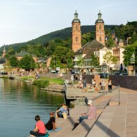 Im Abendrot sonnen sich Leute auf den warmen Steinen der Uferzone. Im Abendrot sonnen sich Leute auf den warmen Steinen der Uferzone.