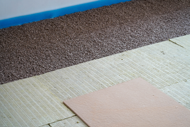 Detailansicht des Bodens: Heizpapier auf einer Lage kleiner Steine, darüber Bodenbelag Detailansicht des Bodens: Heizpapier auf einer Lage kleiner Steine, darüber Bodenbelag