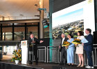 Auf diesem Bild ist eine Bühne mit 5 Personen zu sehen. Zwei Frauen haben Blumensträuße in der Hand.