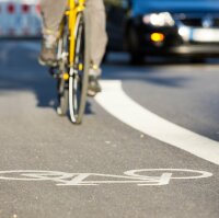 Ein Fahrrad auf einem Radweg neben einer Straße