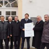 Hans Reichhart übergibt einen Förderbescheid über 384.000 Euro für den Erhalt von Wohnplätzen