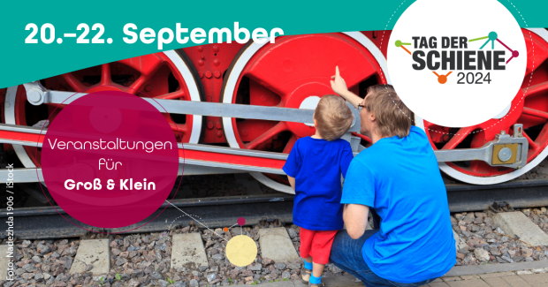 Vater und Sohn schauen sich eine Lokomotive am Tag der Schiene an. Vater und Sohn schauen sich eine Lokomotive am Tag der Schiene an.