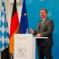 Bauminister Christian Bernreiter steht an einem Rednerpult und spricht. Bauminister Christian Bernreiter steht an einem Rednerpult und spricht.