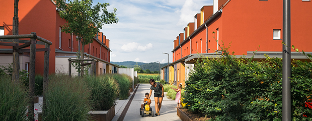 Kinder spielen mit ihrer Mutter in den barrierefrei gestalteten Freianlagen eines Wohnquartiers in Regenstauf. Kinder spielen mit ihrer Mutter in den barrierefrei gestalteten Freianlagen eines Wohnquartiers in Regenstauf.
