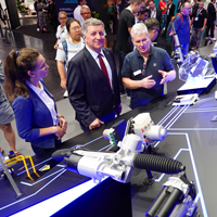 Verkehrsminister Christian Bernreiter lässt sich an einem Messestand von einer Frau und einem Mann etwas erklären Verkehrsminister Christian Bernreiter lässt sich an einem Messestand von einer Frau und einem Mann etwas erklären