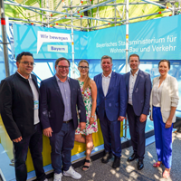 Gruppenfoto mit Vertreterinnen und Vertretern der Kommunen und Verkehrsminister Christian Bernreiter am Messestand des StMB